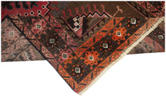 A handmade Afghan Baluch rug featuring geometric patterns in shades of orange, brown, and red.