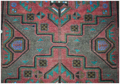 Handmade Afghan Pashm rug featuring a geometric tribal pattern in shades of red, brown, and blue.