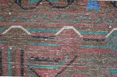 A handmade Afghan Pashm rug featuring a tribal pattern in dark red, brown, blue, and ivory tones.