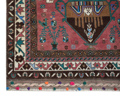 Handmade Afghan Pashm rug featuring a tribal pattern in red, brown, and blue with tassel fringe.