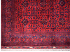 An Afghan Biljik rug featuring a deep red field with intricate blue geometric floral patterns.