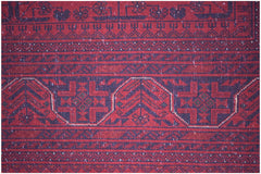 A close-up of an Afghan Biljik rug featuring intricate geometric patterns in deep red and blue.