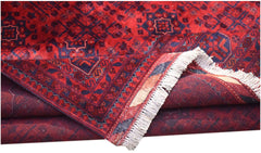 A handmade Afghan Biljik rug featuring deep red and blue geometric patterns with a fringed edge.