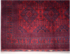 A handmade Afghan Biljik wool rug featuring intricate geometric patterns in deep red and blue.