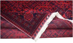 A handmade Afghan Biljik rug featuring deep red and blue geometric patterns with white fringe.