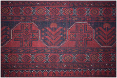 A handmade Afghan Biljik rug featuring intricate geometric patterns in deep red and blue wool.