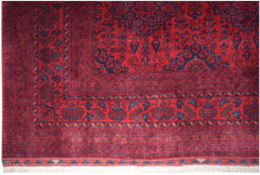 Handmade Afghan Biljik rug featuring intricate geometric patterns in deep red and blue wool.
