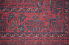 A close-up of a handmade Afghan Biljik rug featuring intricate floral and geometric patterns in red.