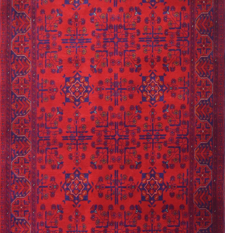 An Afghan Biljik runner featuring a deep red field with intricate blue geometric floral patterns.