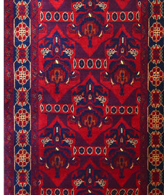 An Afghan Biljik runner featuring a geometric pattern in deep red and blue wool.