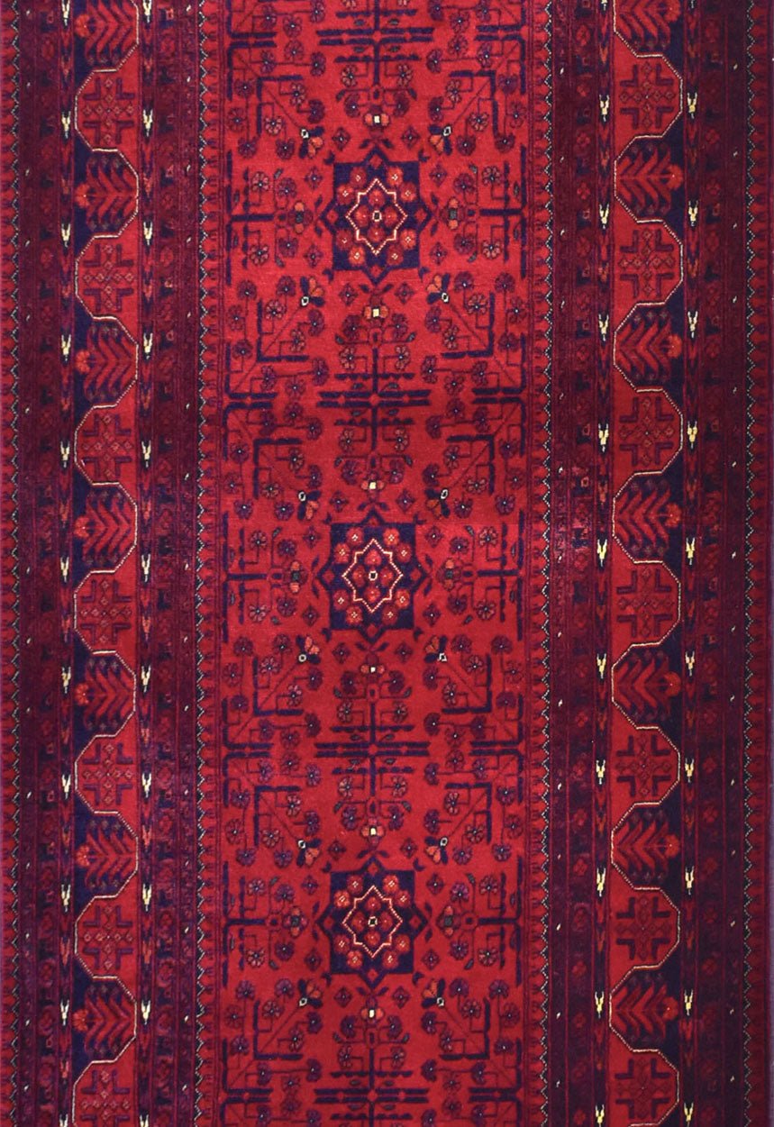An Afghan Biljik runner rug featuring deep red tones and intricate geometric floral patterns.
