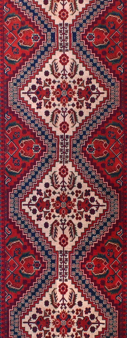 An Afghan Biljik runner rug featuring a geometric pattern in deep red and blue wool.