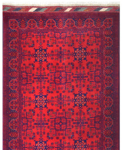 An Afghan Biljik runner featuring a deep red field with intricate blue geometric floral patterns.