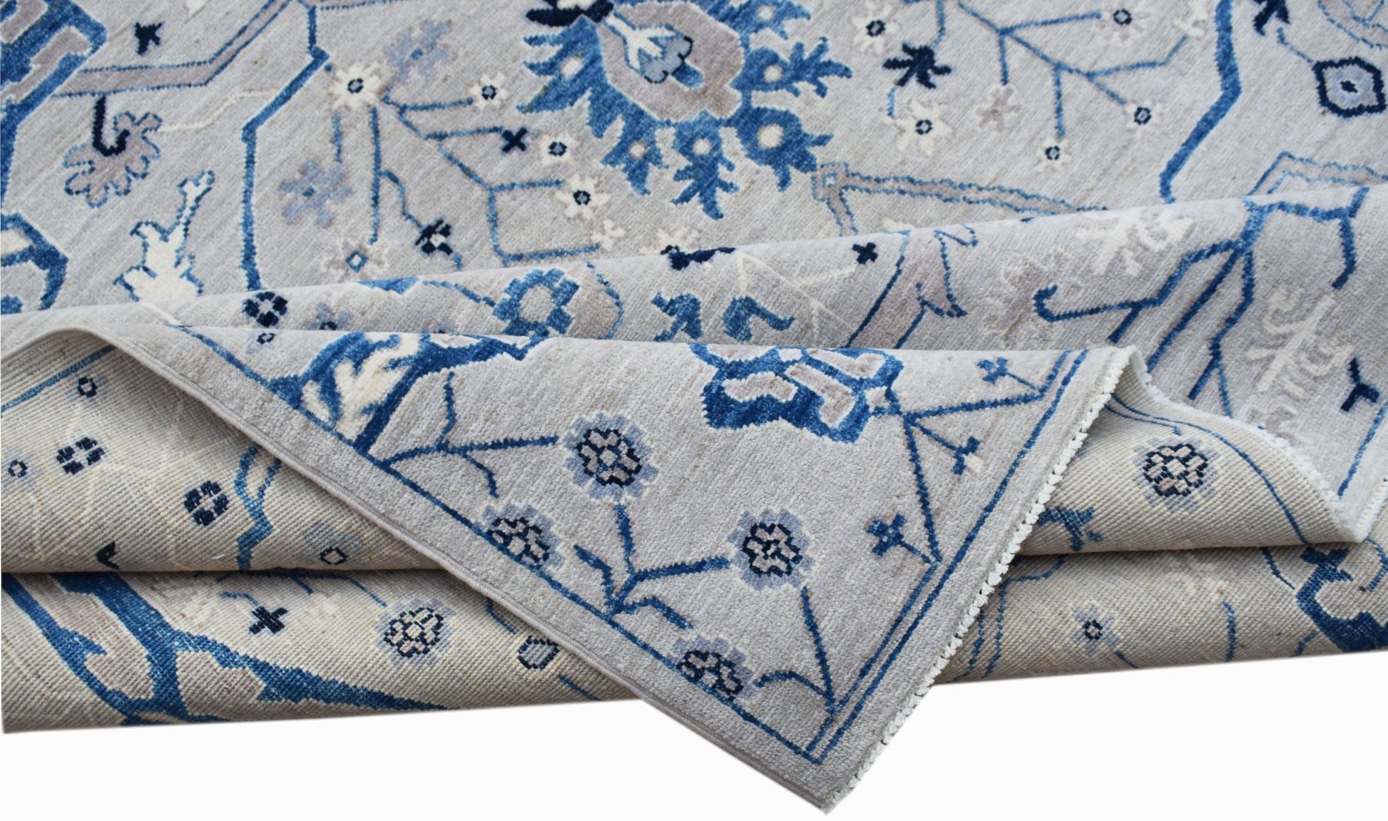 A handwoven Afghan Chobi rug featuring a traditional blue and grey floral pattern.