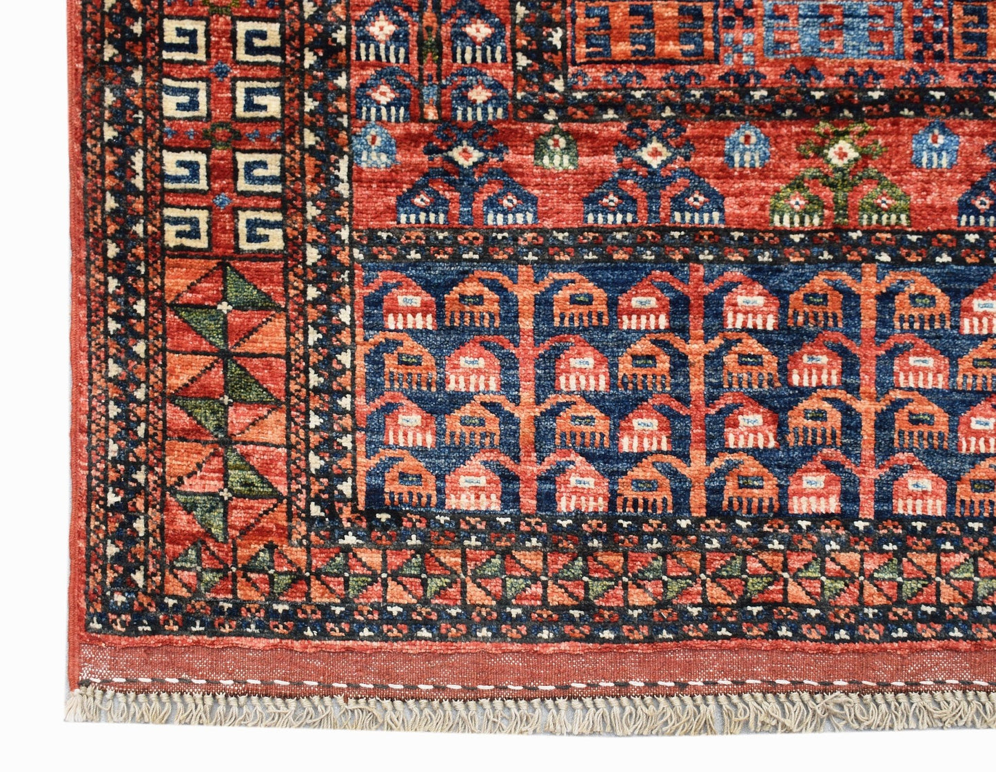 A handwoven Afghan Chobi rug featuring a traditional geometric Engsi pattern in red and blue.