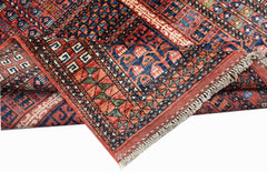 A handwoven Afghan Chobi rug featuring traditional geometric patterns in red, blue, and ivory.