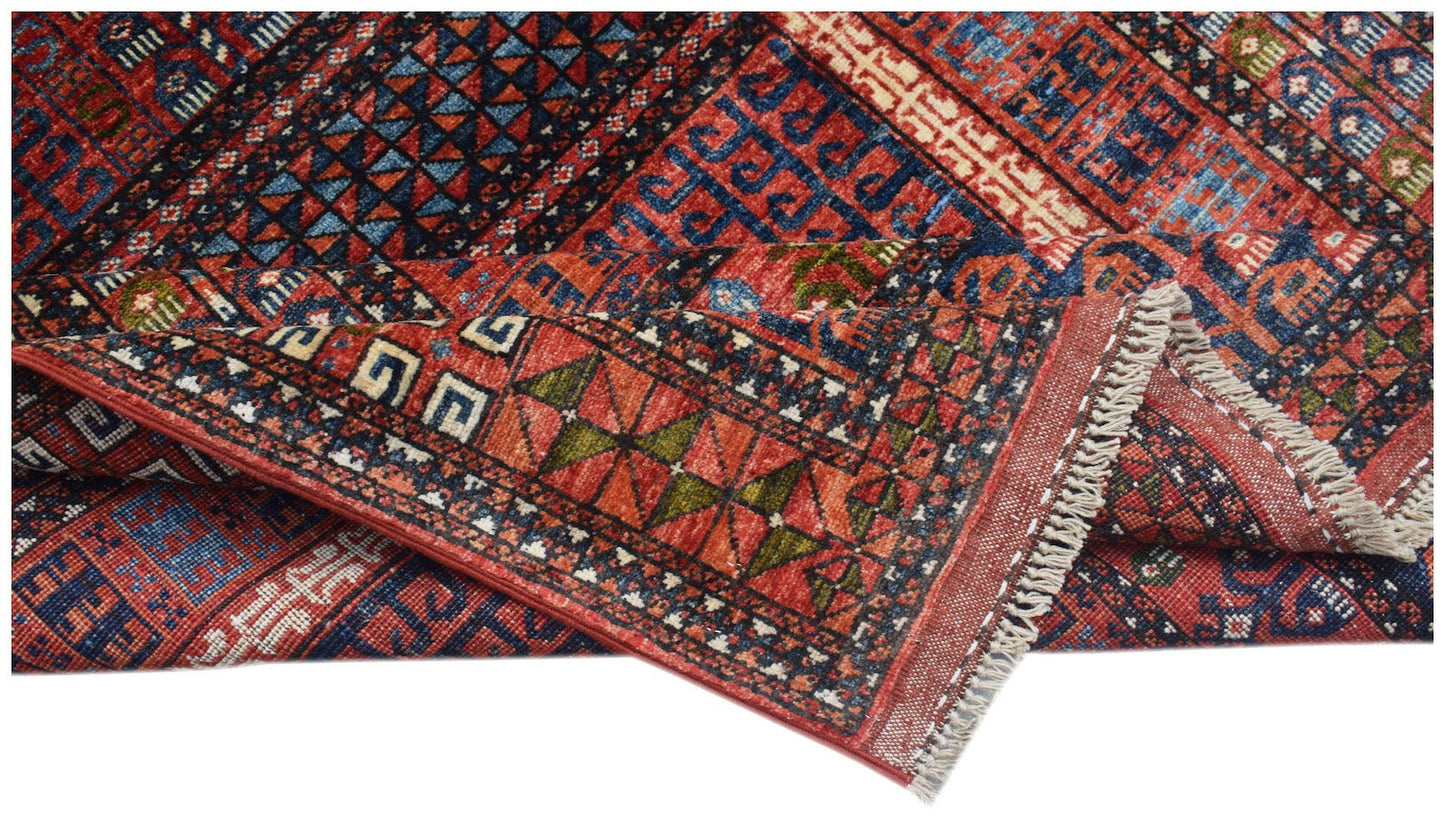 A handwoven Afghan Chobi rug featuring traditional geometric patterns in red, blue, and ivory.