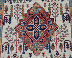 A handwoven Afghan Chobi rug featuring a central red medallion with intricate floral motifs.