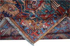 Handmade Afghan Chobi rug featuring a geometric Heriz pattern in shades of red, blue, and brown.