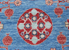A handmade Afghan Chobi rug featuring a central red medallion with floral motifs on a blue field.