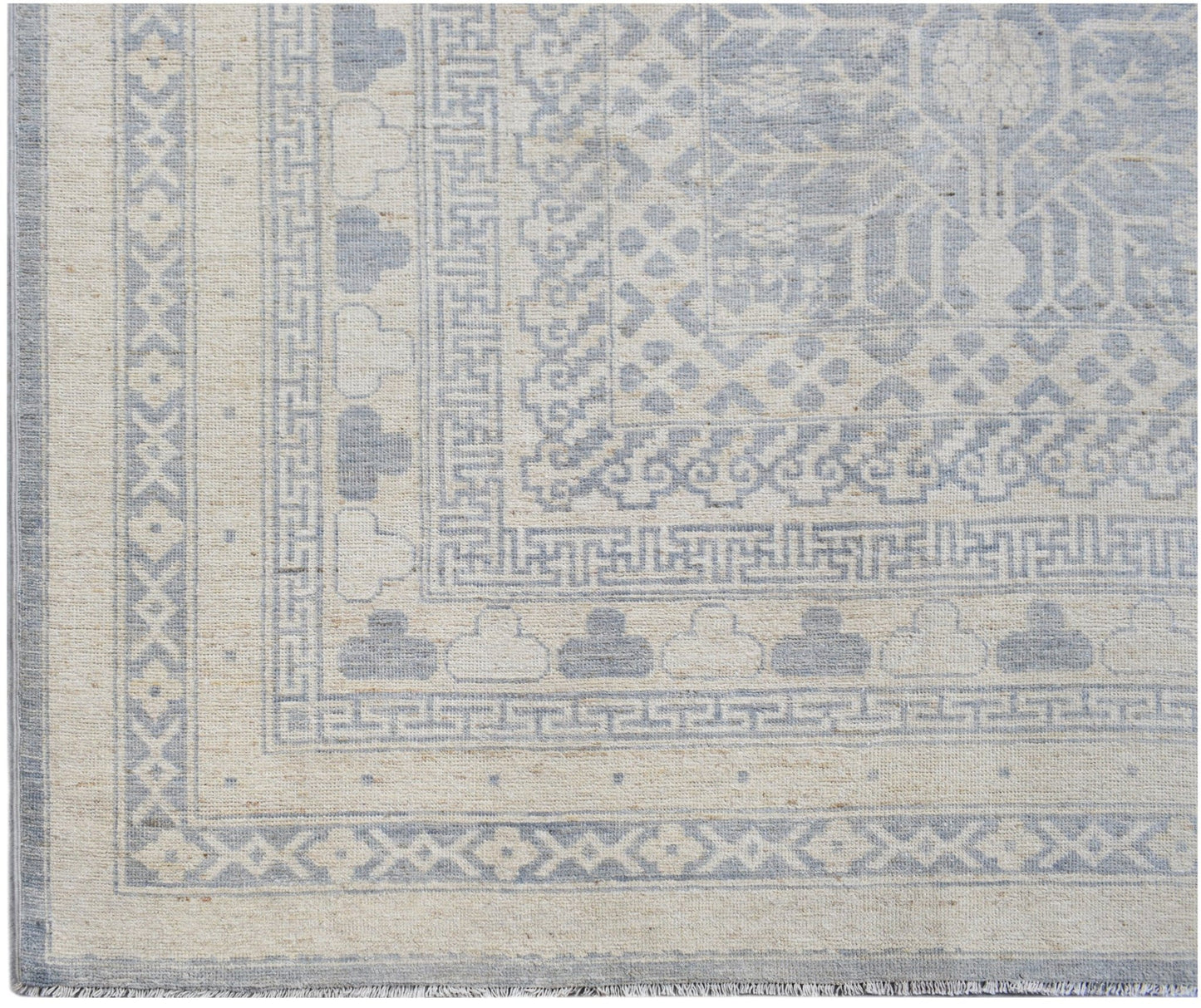 An Afghan Chobi rug featuring a light blue and cream geometric Khotan pattern.