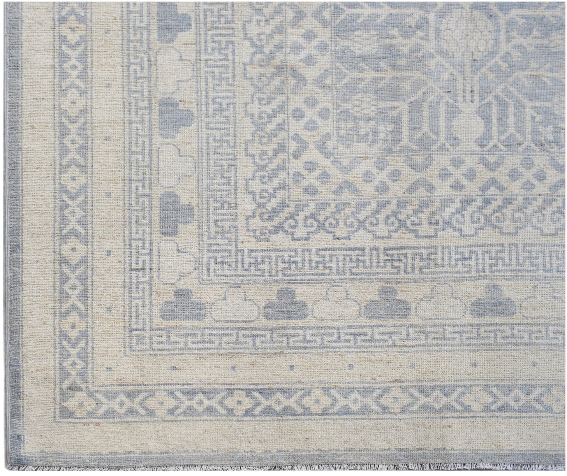 An Afghan Chobi rug featuring a light blue and cream geometric Khotan pattern.