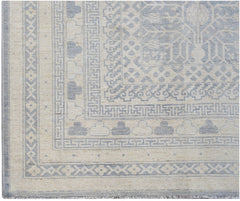 An Afghan Chobi rug featuring a light blue and cream geometric Khotan pattern.