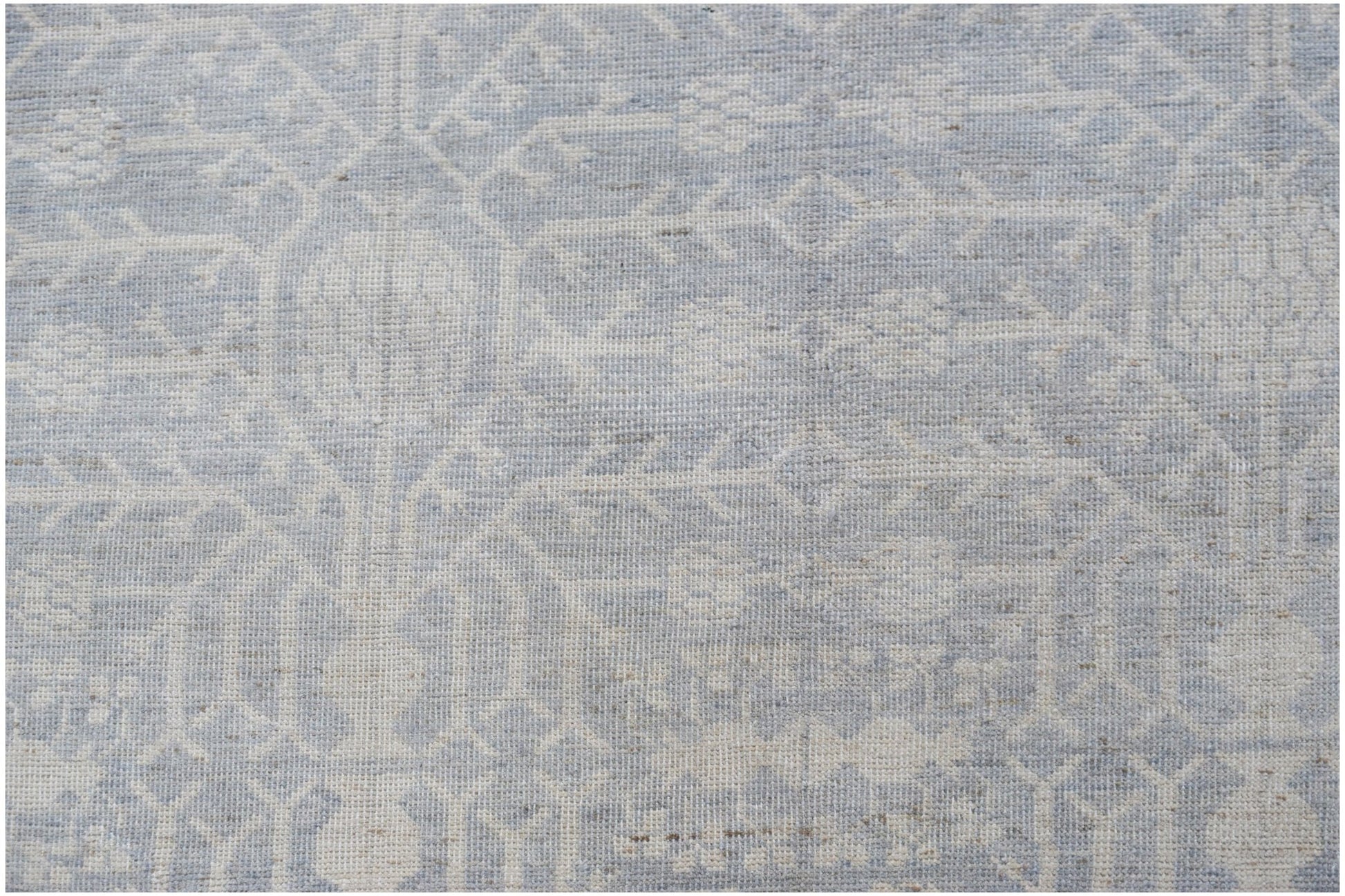 A handwoven Afghan Chobi rug featuring a light blue and cream traditional Khotan pattern.