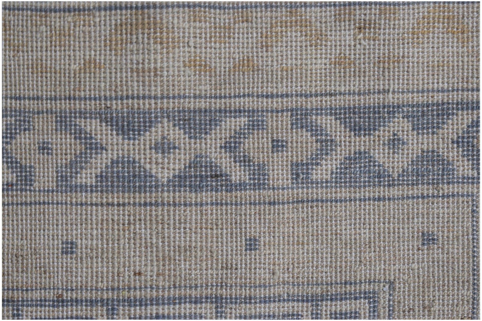 A handwoven Afghan Chobi rug featuring a geometric border pattern in blue and beige tones.