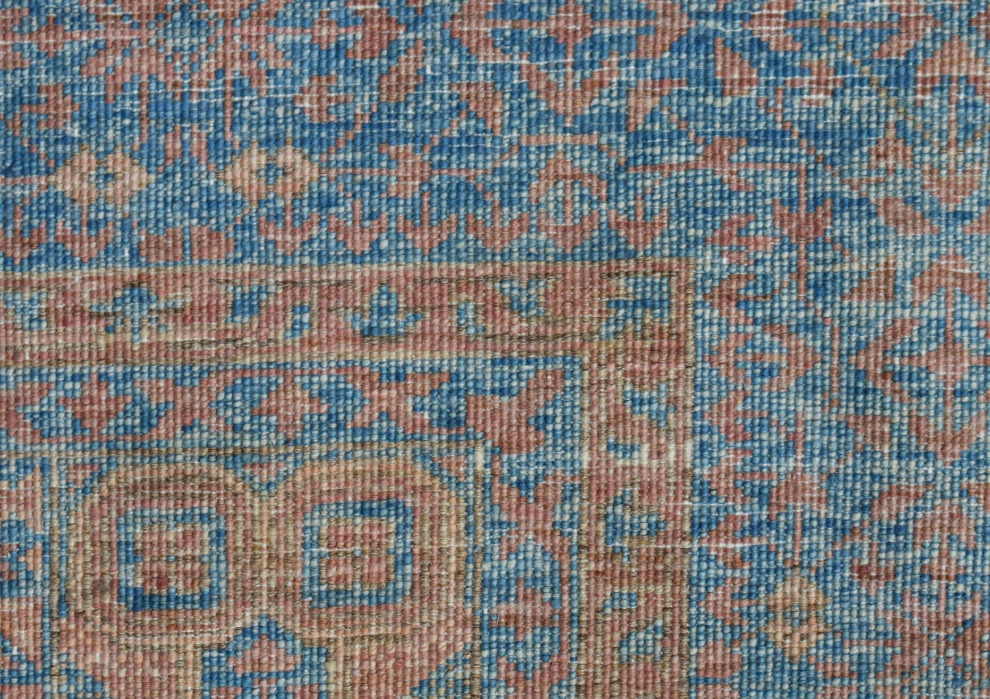 A close-up of a handwoven Afghan Chobi rug featuring a detailed Mamluk pattern in blue and tan.