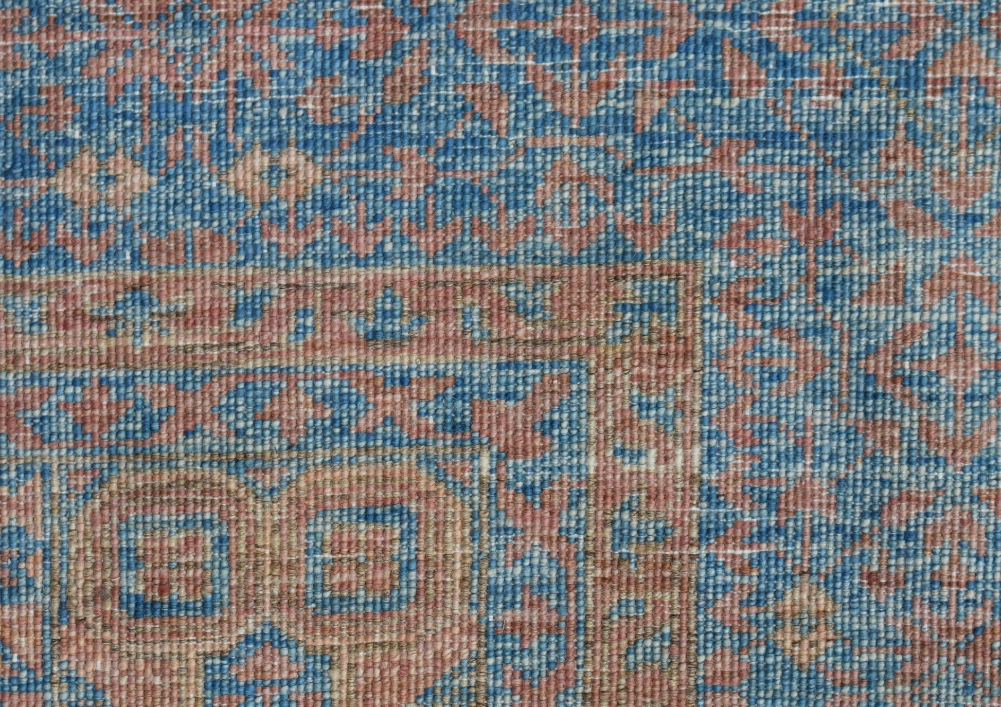 A close-up of a handwoven Afghan Chobi rug featuring a detailed Mamluk pattern in blue and tan.
