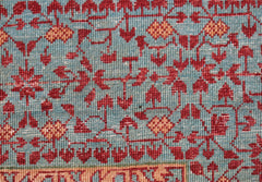 A close-up of a handwoven Afghan Chobi rug featuring a detailed red and orange Mamluk pattern.