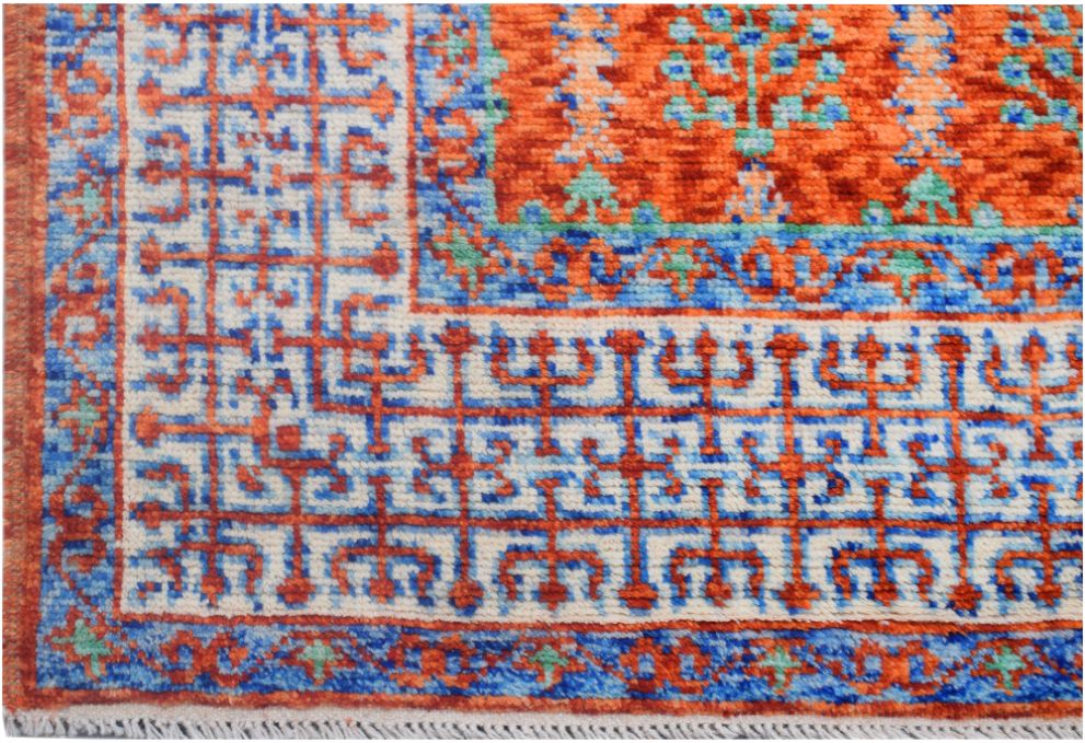 A handmade Afghan Chobi rug featuring a geometric Mamluk pattern in orange, blue, and cream.