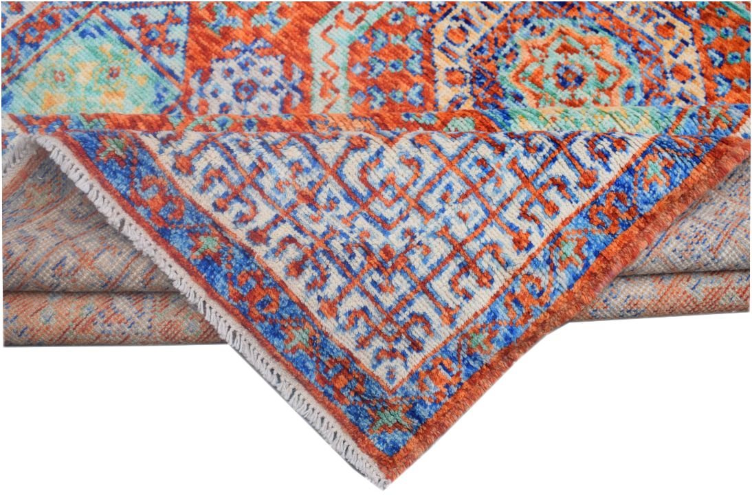 A handmade Afghan Chobi rug featuring a vibrant geometric Mamluk pattern in orange and blue.