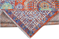 A handmade Afghan Chobi rug featuring a vibrant geometric Mamluk pattern in orange and blue.