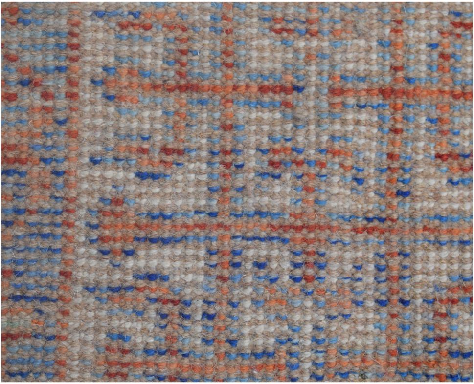 A close-up of a handmade Afghan Chobi rug featuring a geometric grid pattern in blue and orange.