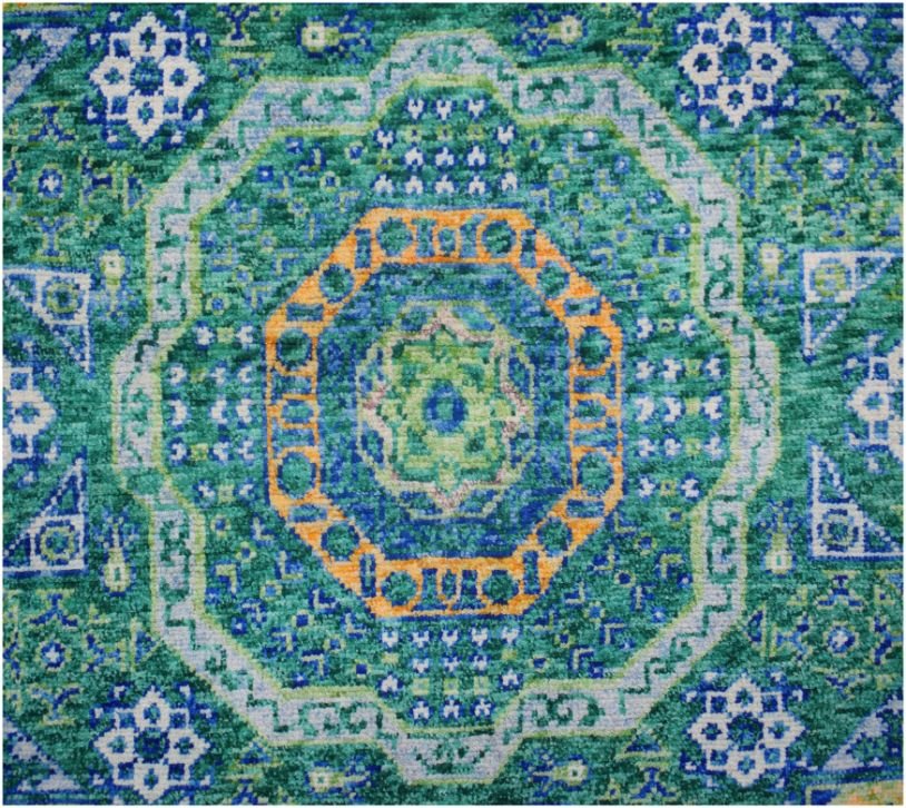 Handmade Afghan Chobi rug featuring a complex geometric medallion in shades of green and orange.