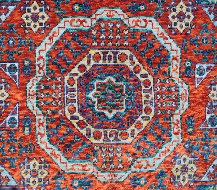 Handmade Afghan Chobi rug featuring a complex geometric medallion in red, blue, and cream tones.