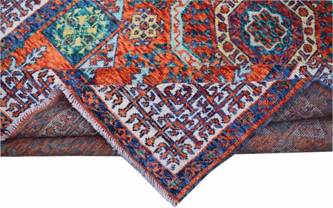 A handmade Afghan Chobi rug featuring a vibrant geometric Mamluk pattern in orange and blue.