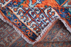 A handmade Afghan Chobi Mamluk rug featuring a geometric pattern in blue, orange, and cream.