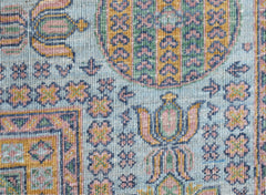 A close-up of a handwoven Afghan Chobi rug featuring intricate floral patterns in soft pastel tones.