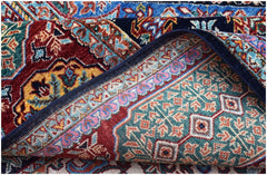 A corner of a handwoven Afghan Chobi rug with a Mamluk pattern in red, blue, and teal tones.