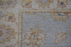 A close-up of an Afghan Chobi rug featuring a floral pattern in muted earth tones on a wool pile.