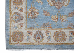 A handmade Afghan Chobi rug featuring a light blue field with floral patterns and a cream border.