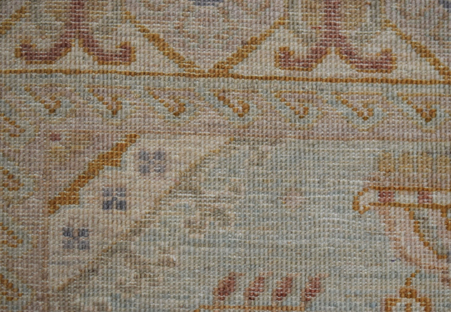 A close-up of a handwoven Afghan Chobi rug featuring traditional patterns in earthy wood tones.