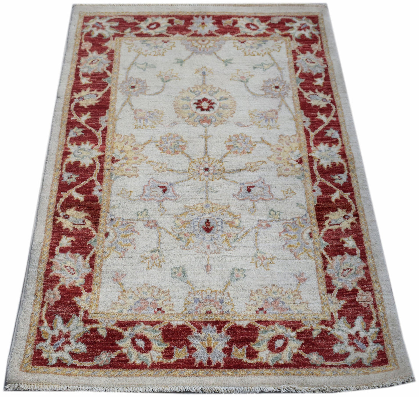 A rectangular Afghan Chobi rug featuring a cream field with floral motifs and a red border.
