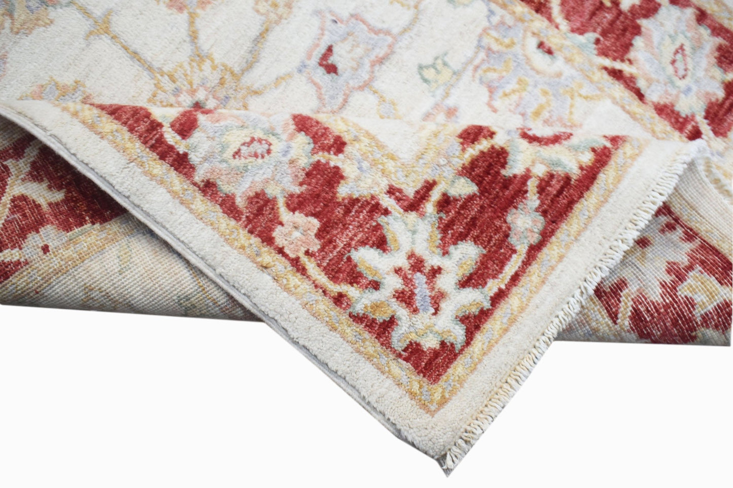 A handwoven Afghan Chobi rug featuring a traditional floral pattern in red and cream tones.