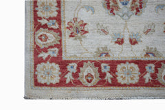 A handmade Afghan Chobi rug featuring a red floral border on a cream background.