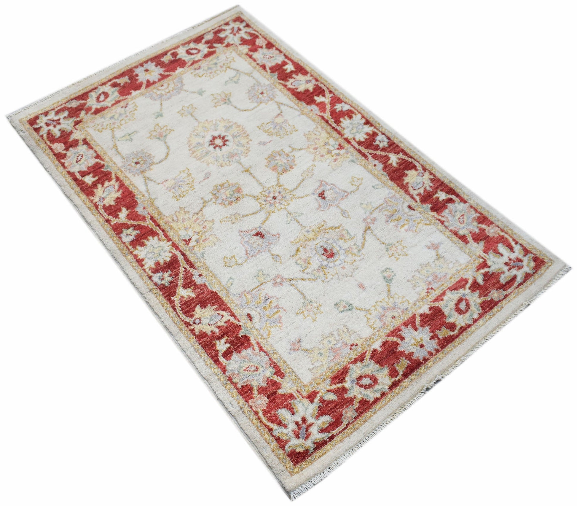 An Afghan Chobi rug featuring a cream field with floral motifs and a bold red border.