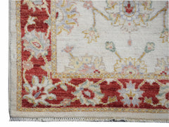 Handwoven Afghan Chobi rug featuring a traditional floral pattern in red and cream tones.